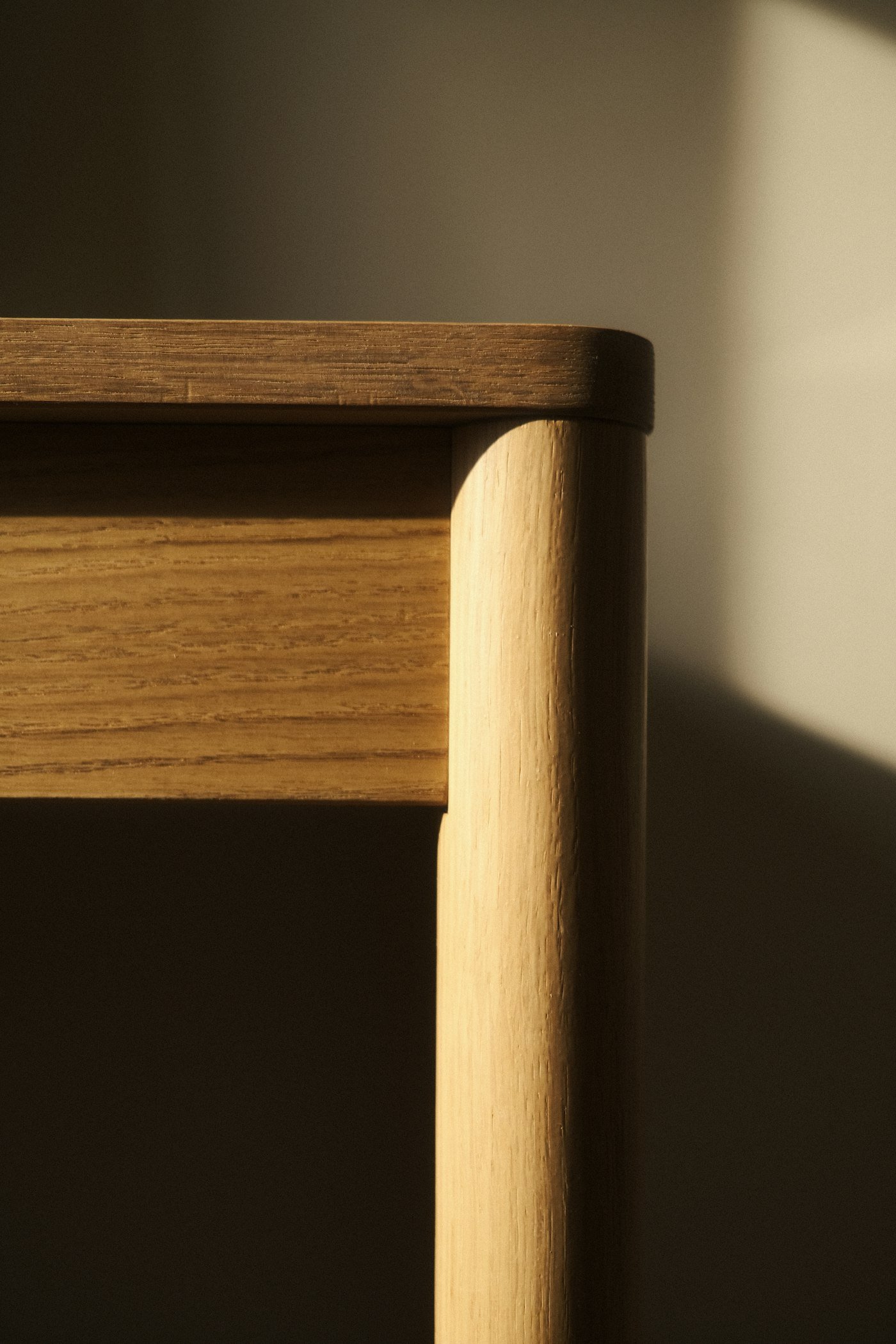 Gros plan sur le dossier d’une chaise en bois devant une fenêtre
