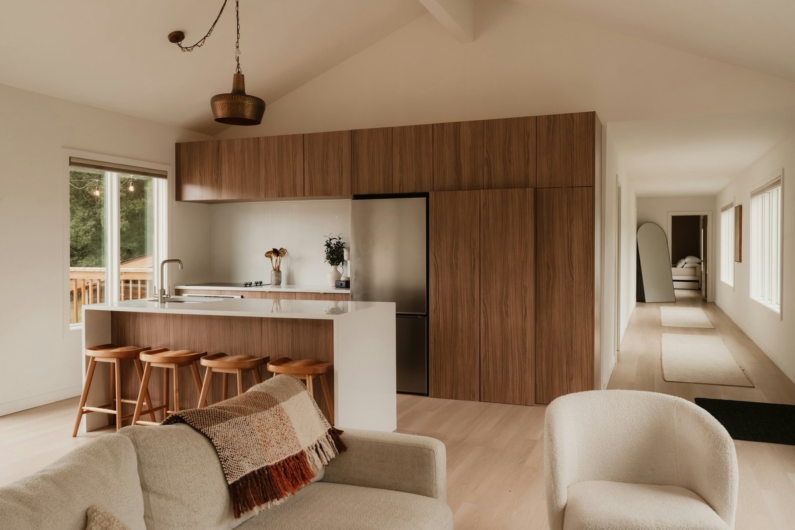 Mur de rangements en noyer toute hauteur dans une cuisine ouverte