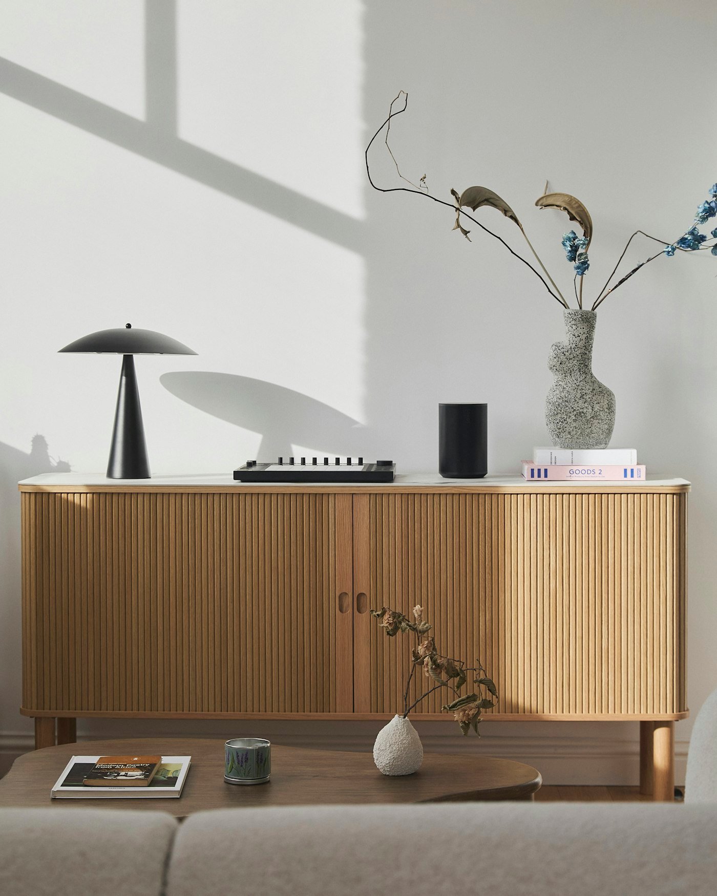 Enfilade basse en bois clair avec lampe et objets décoratifs