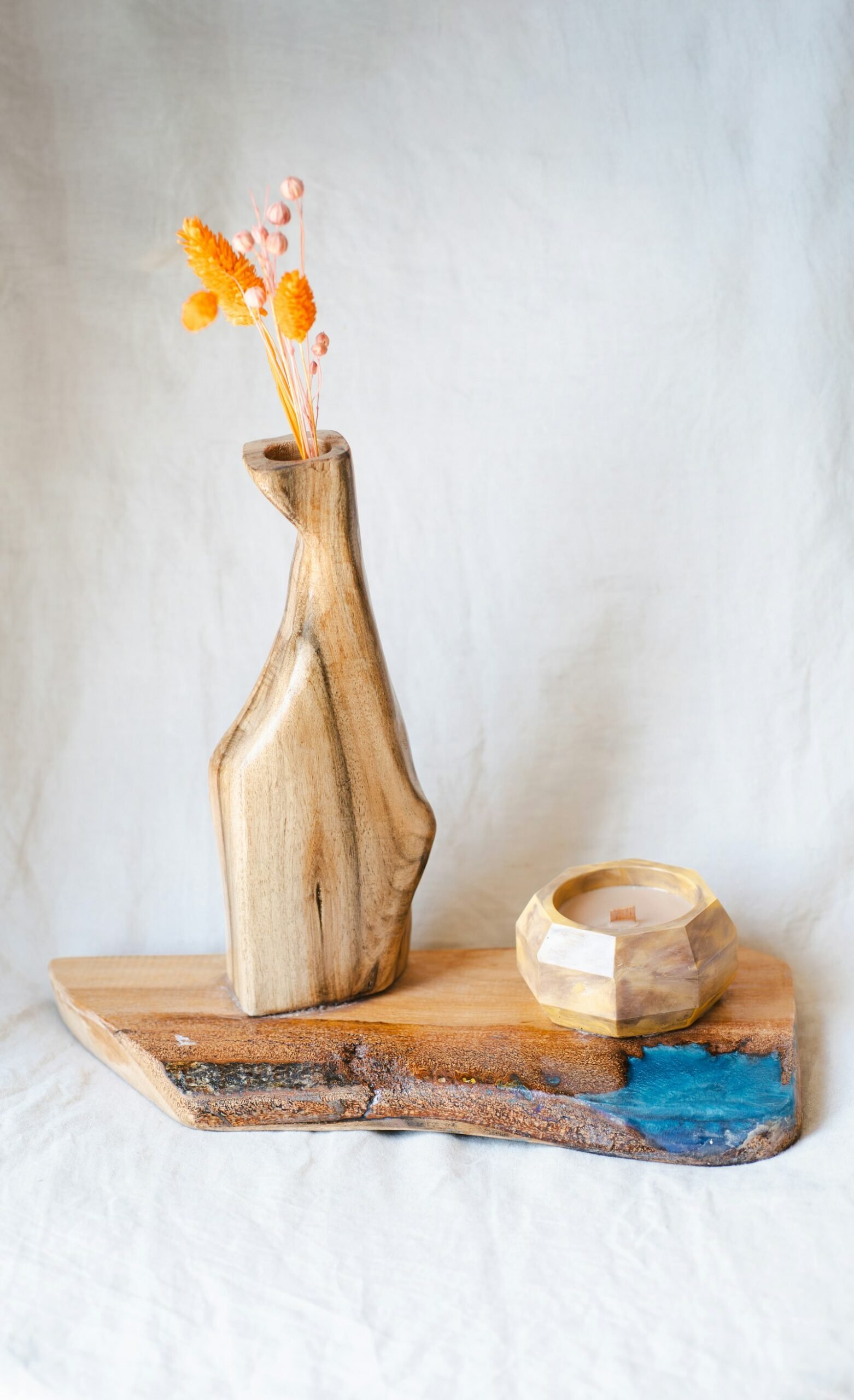 Vase sculpté et petite coupe en bois massif posés sur une étagère